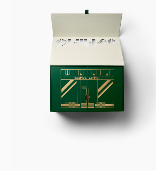 An open, green gift box for Graffeo coffee with a gold storefront design.