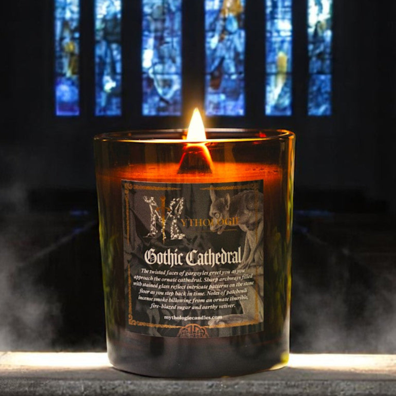 Lit candle labeled 'Gothic Cathedral' in front of colorful stained glass.