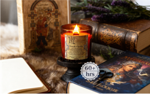 Lit candle surrounded by books, notebook, lavender, and scissors.