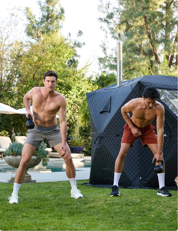Two people exercising outdoors with kettlebells near a portable sauna.