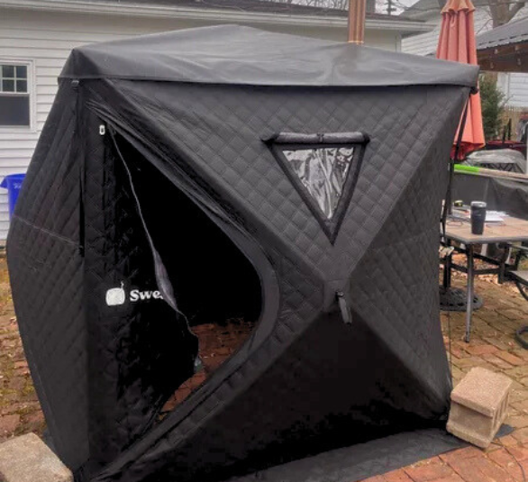 Black outdoor tent with a triangular window and partially open entrance.