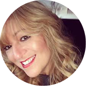 A circular headshot of a smiling woman with blonde, wavy hair looking at the camera.