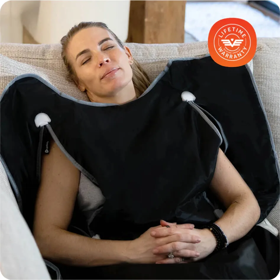 Person relaxing on a couch with a black massage blanket.