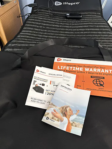 A Lifepro heated mat shown with its controller, user manual, and other branded pamphlets.