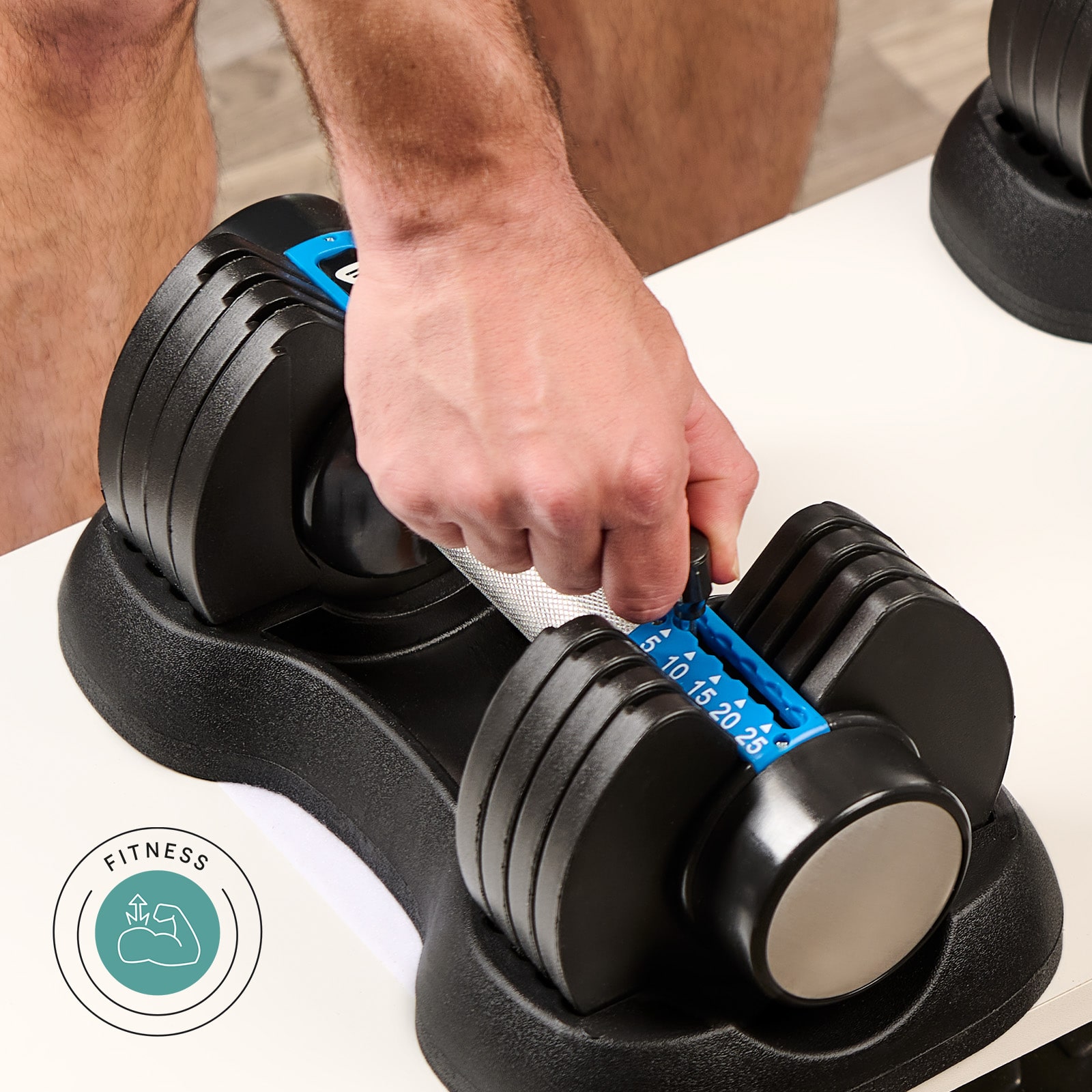 Person adjusting weight on an adjustable dumbbell.