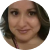 A blurry, circular headshot of a woman with brown hair looking towards the camera.