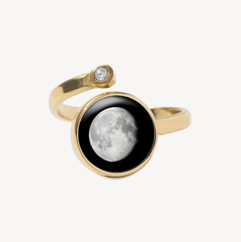 Gold ring with moon design and small gemstone.