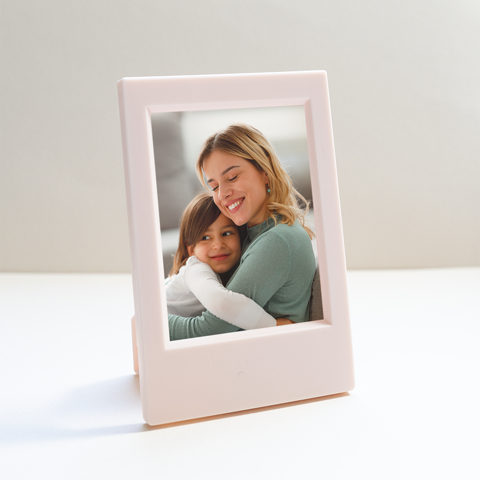 A photo in a frame of a woman hugging a child lovingly.