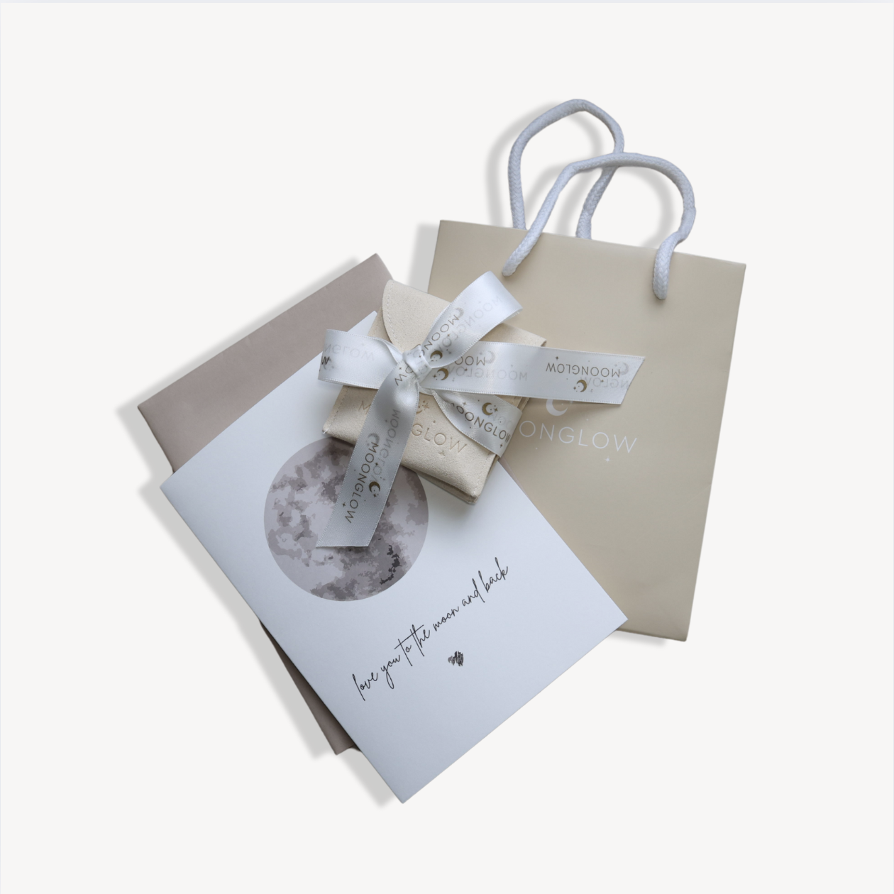 Gift bag with card and ribboned box, featuring moon design.