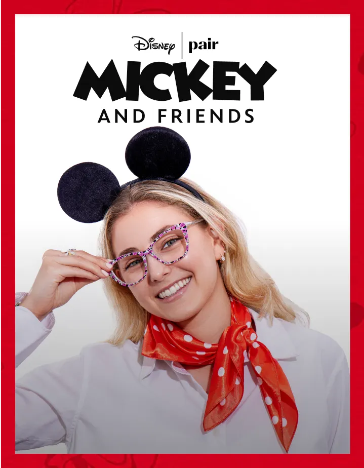 Smiling woman wearing Mickey Mouse ears, glasses, and red polka-dot scarf.