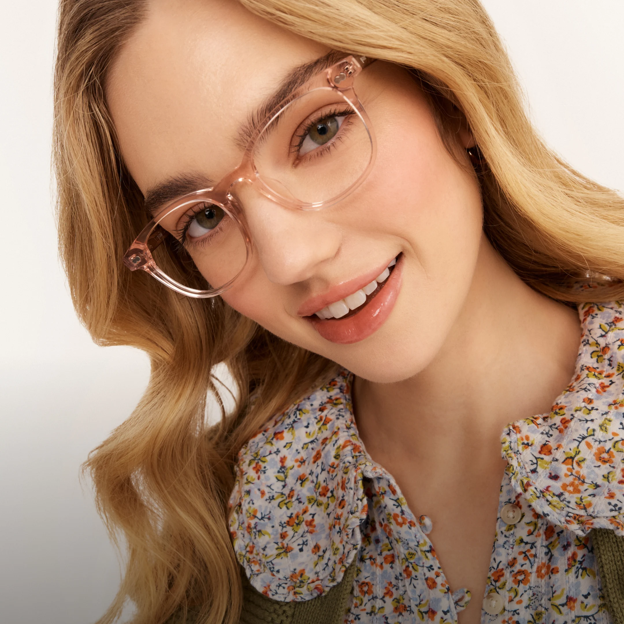Person with glasses smiling, wearing a floral shirt.