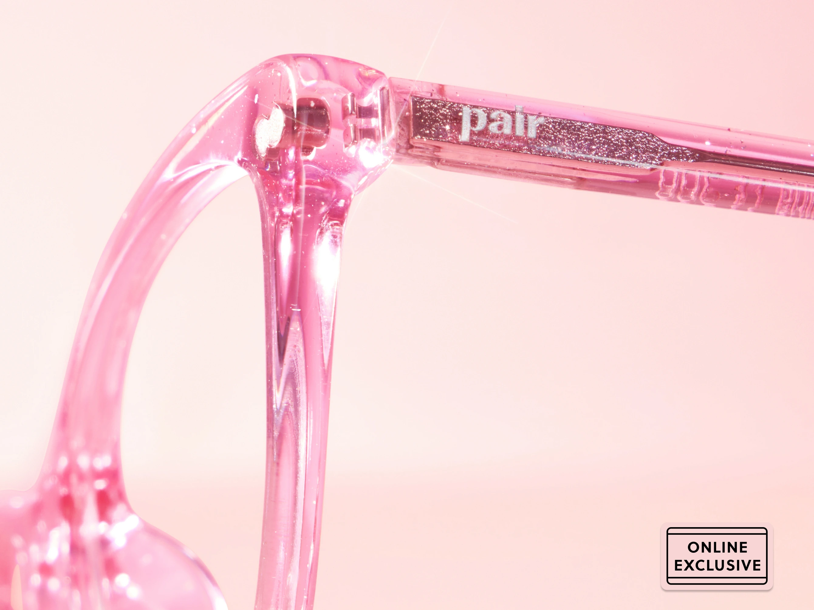 Close-up of pink glasses frame with glitter detail.