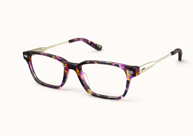 A pair of purple, black, and amber tortoiseshell eyeglasses with thin silver arms on a white background.