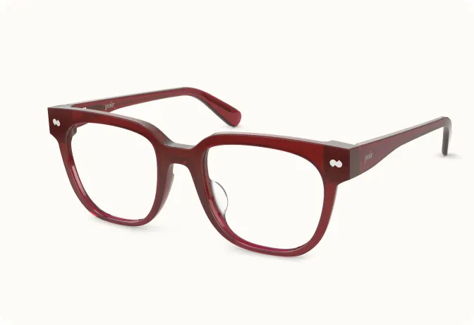 A pair of dark red, thick-framed eyeglasses shown at an angle on a white background.