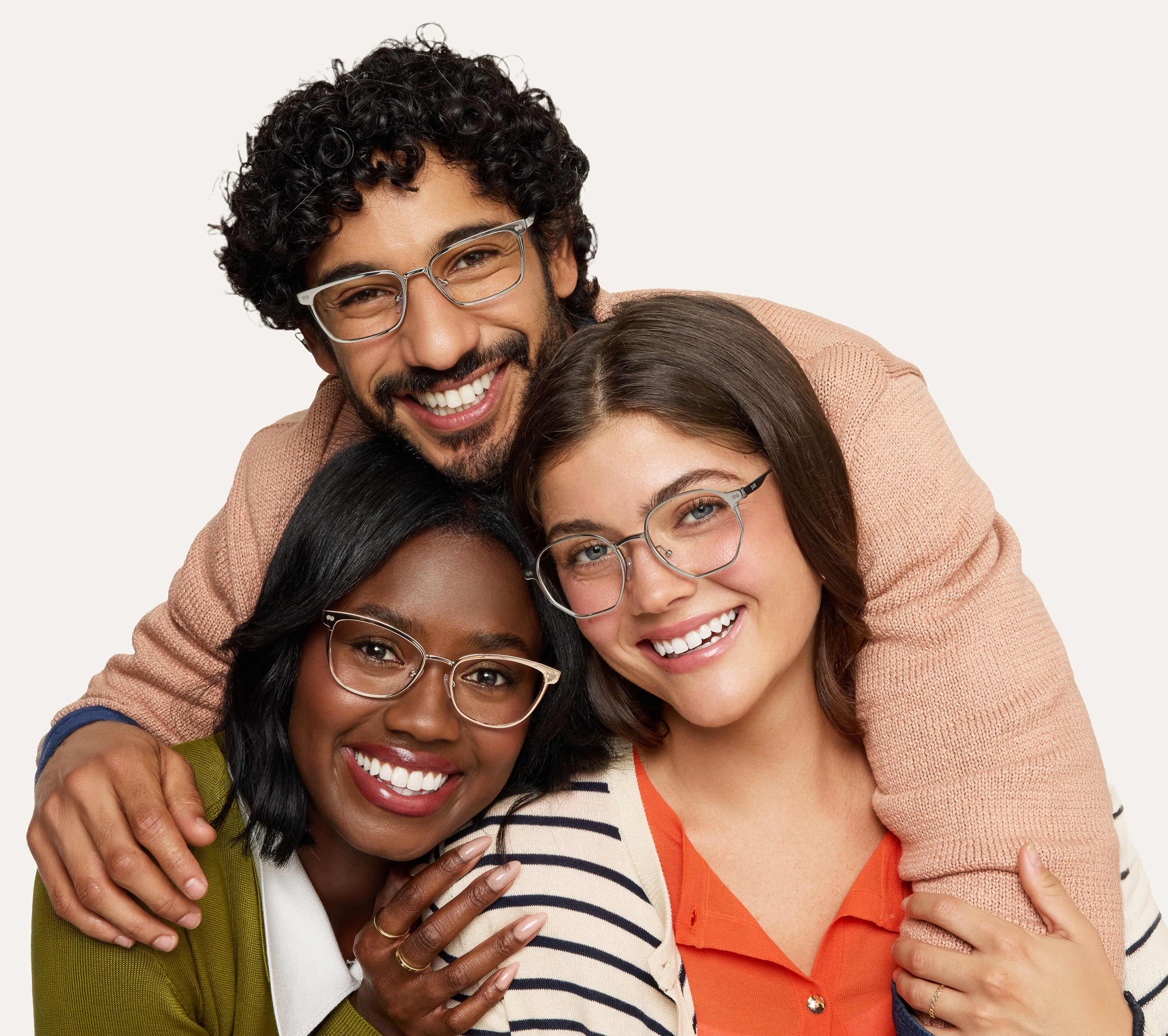 Three people wearing glasses, smiling and embracing each other.