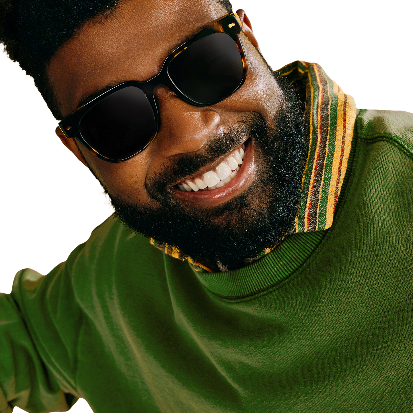 Smiling person wearing sunglasses and a green shirt with striped collar.