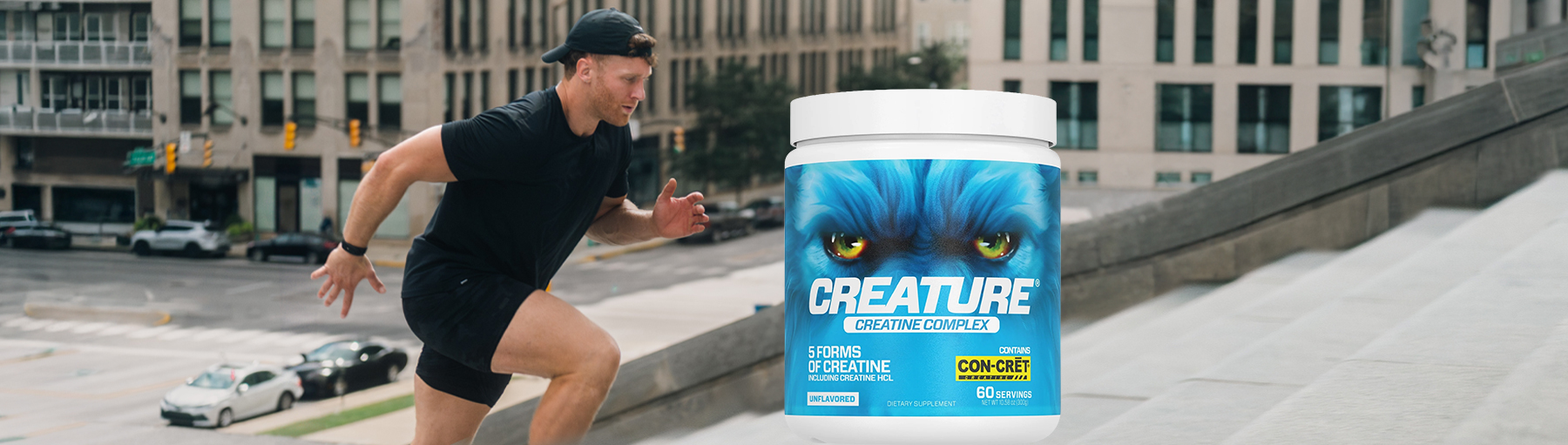 A man in athletic wear runs up concrete stairs next to a container of Creature Creatine Complex.