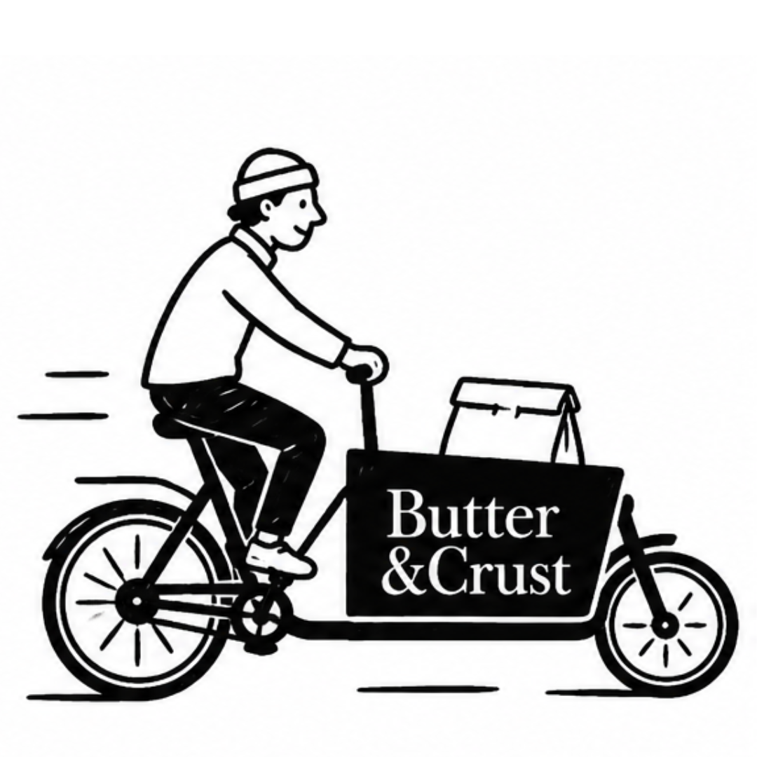 A black and white illustration of a person riding a 'Butter & Crust' cargo delivery bike.