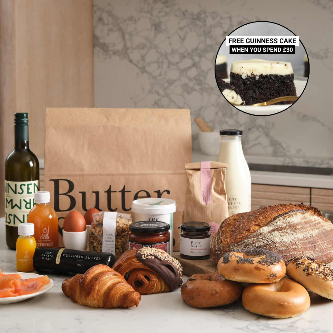 An assortment of fresh bakery items, dairy products, and other groceries arranged on a kitchen counter.
