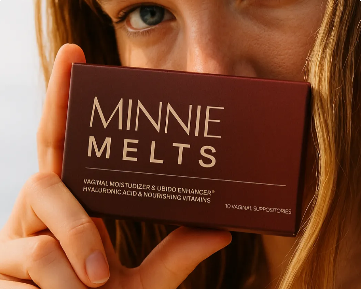 A close-up of a woman holding a box of Minnie Melts vaginal moisturizer in front of her face.