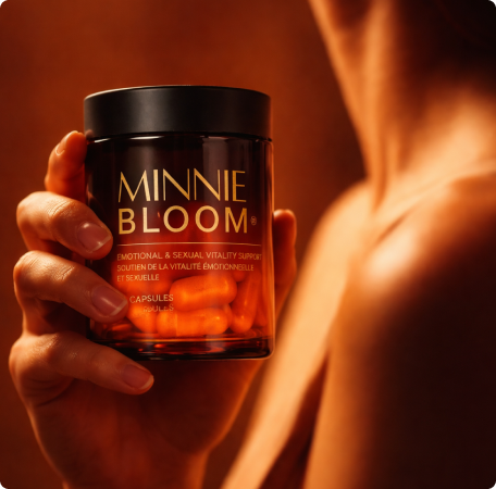A person holds a bottle of Minnie Bloom capsules, with their shoulder and neck visible in the background.