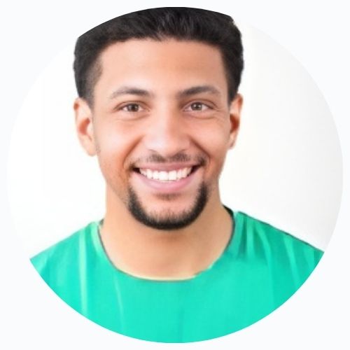 A circular photo of a man with dark hair in a black shirt speaking and gesturing.