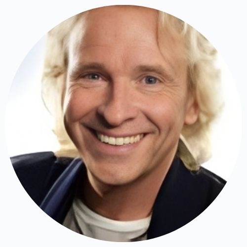 A man in a black jacket and grey pants strikes a dynamic pose, leaning back on his toes.