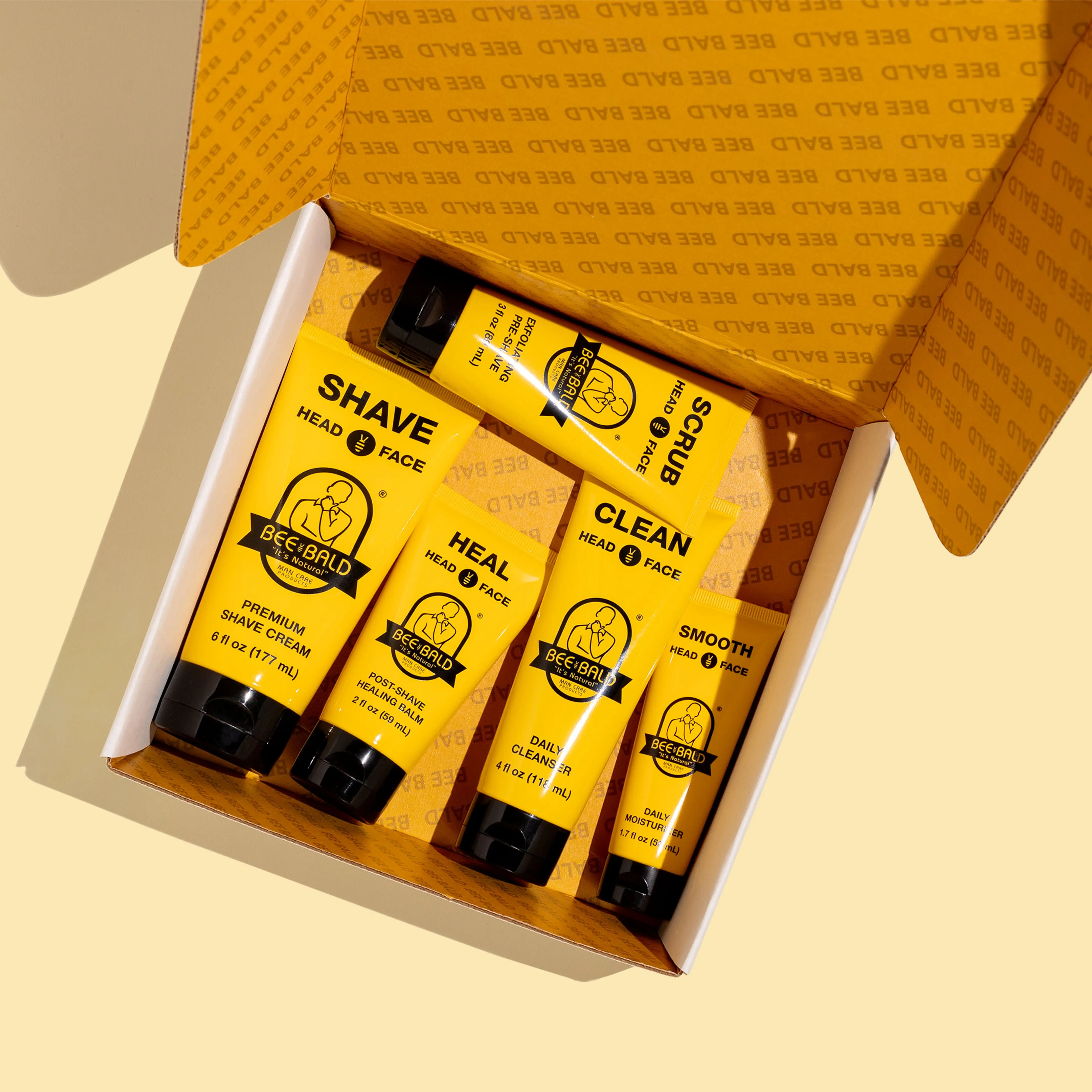 Open box with yellow skincare products labeled for head and face.