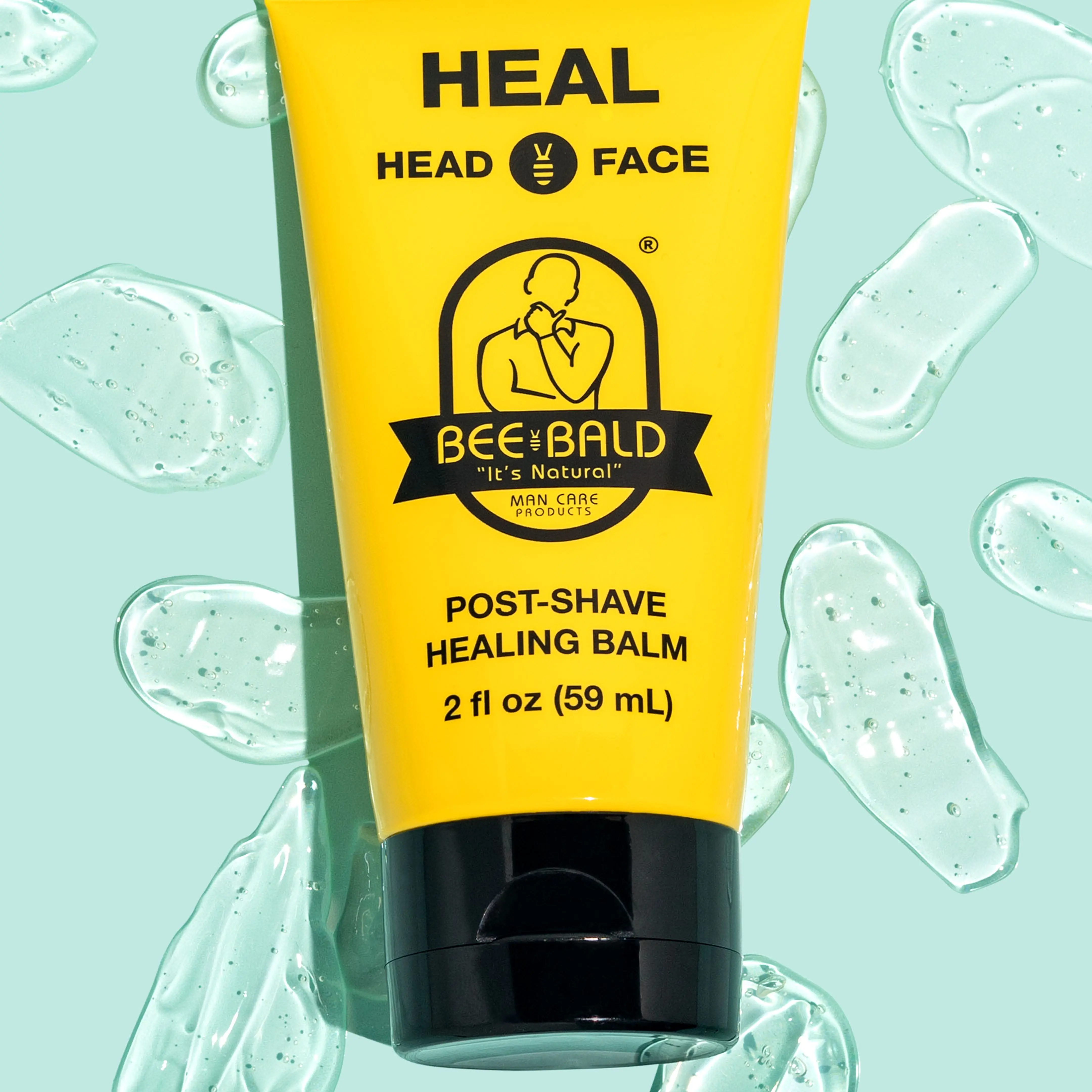 Yellow tube of Bee Bald post-shave healing balm on a light blue background.