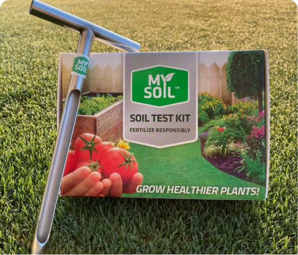 Soil test kit box with metal probe on grass.
