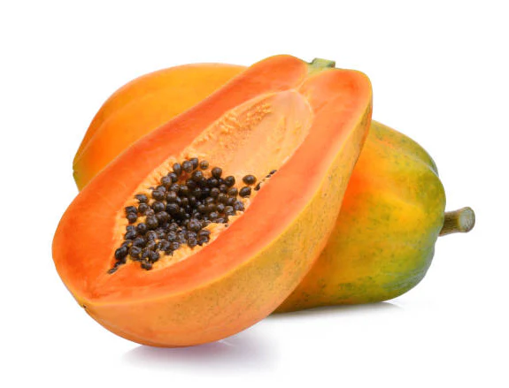 Ripe papaya cut in half with visible seeds, against a white background.