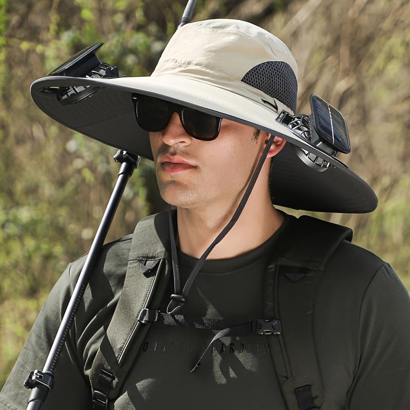 Man wearing a wide-brimmed hat with solar panels and sunglasses outdoors.