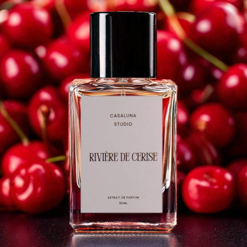 Perfume bottle labeled 'Rivière de Cerise' with cherries in the background.