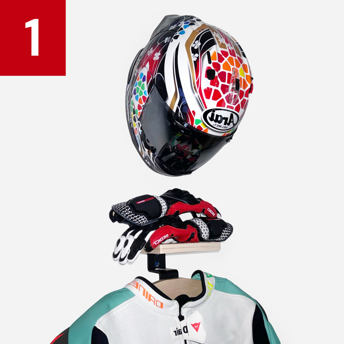 Colorful motorcycle helmet, gloves, and jacket hanging on a wall-mounted stand.