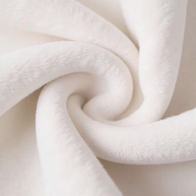 Close-up of white, plush fabric folded in a spiral pattern.