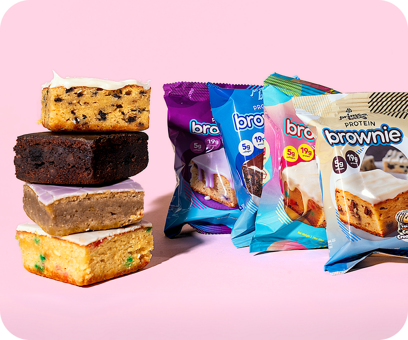 Stacked brownies and colorful packaged protein brownies on a pink background.