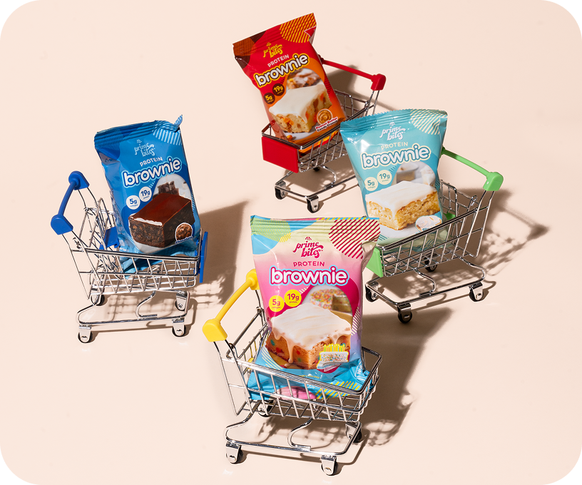 Mini shopping carts holding different packages of protein brownies.
