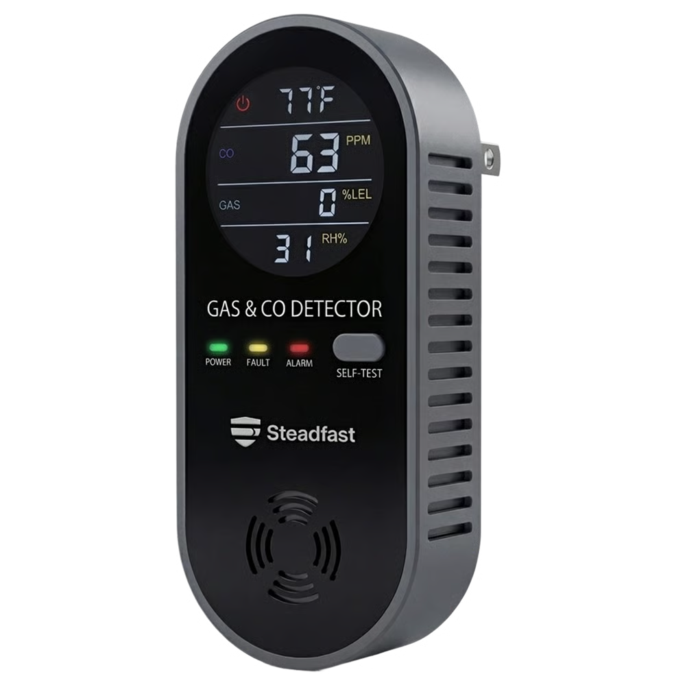 A black and grey plug-in gas and carbon monoxide detector with a digital display showing various readings.