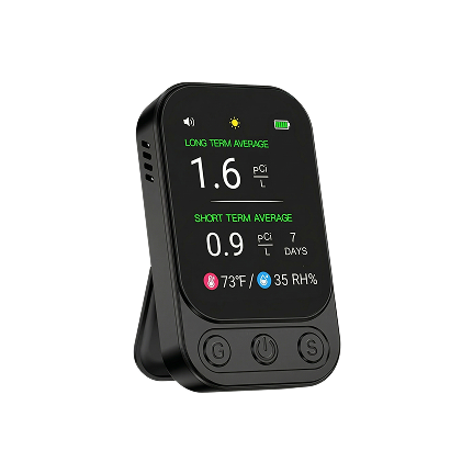 A portable black digital radon detector displaying long-term and short-term averages, temperature, and humidity.