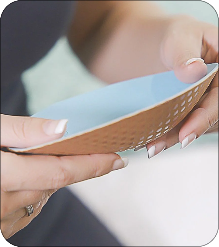 Person holding a blue and brown textured bowl.