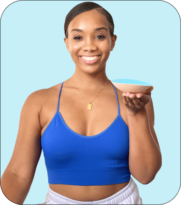 Smiling person holding a small bowl against a blue background.