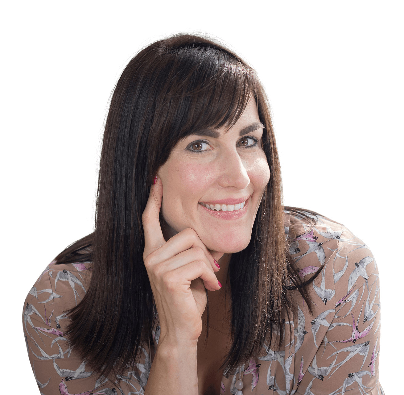 Smiling woman with dark hair, wearing a floral top, resting her chin on her hand.