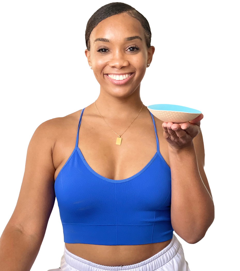 Smiling woman in blue sports bra holding beige and turquoise Honey Cloudz Plus Collection bra insert with extra padding for fuller shaping and secure fit.