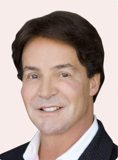 Portrait of a smiling man with dark hair in a suit.