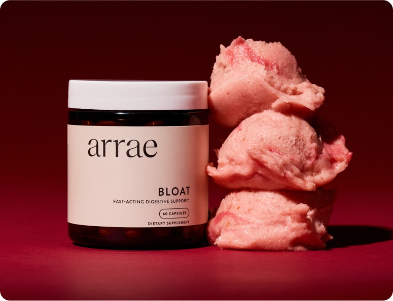 Jar of Arrae Bloat capsules next to pink ice cream scoops on a red background.