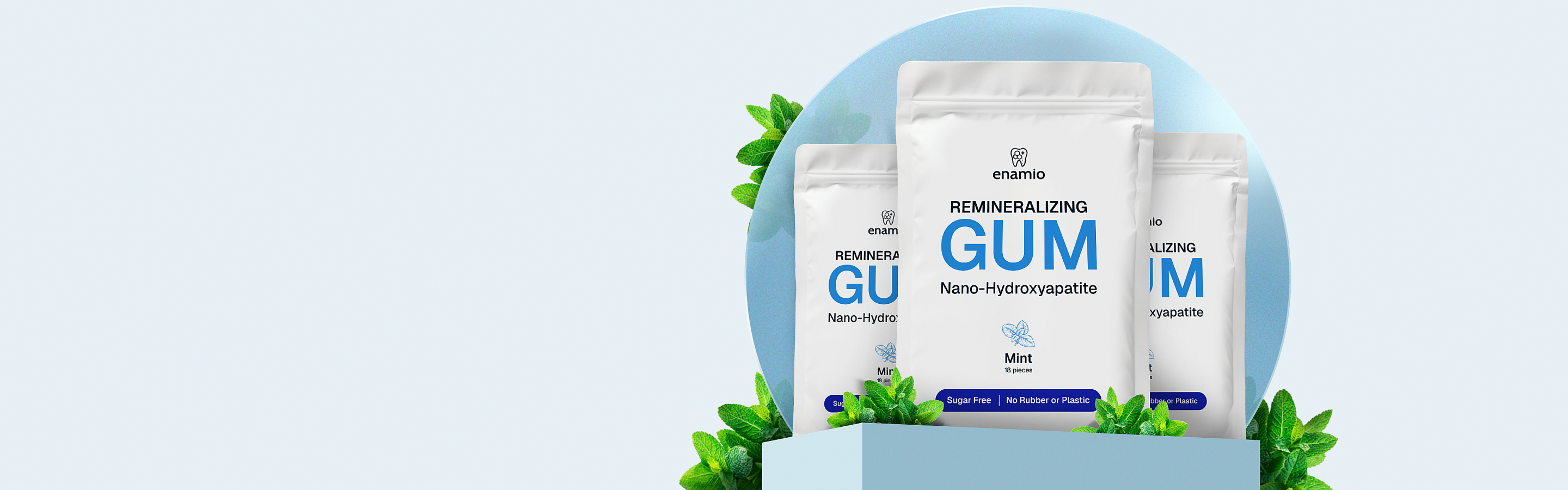 Three packs of remineralizing gum with mint leaves around.