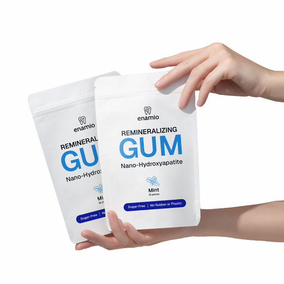 Hands holding two packs of remineralizing gum.