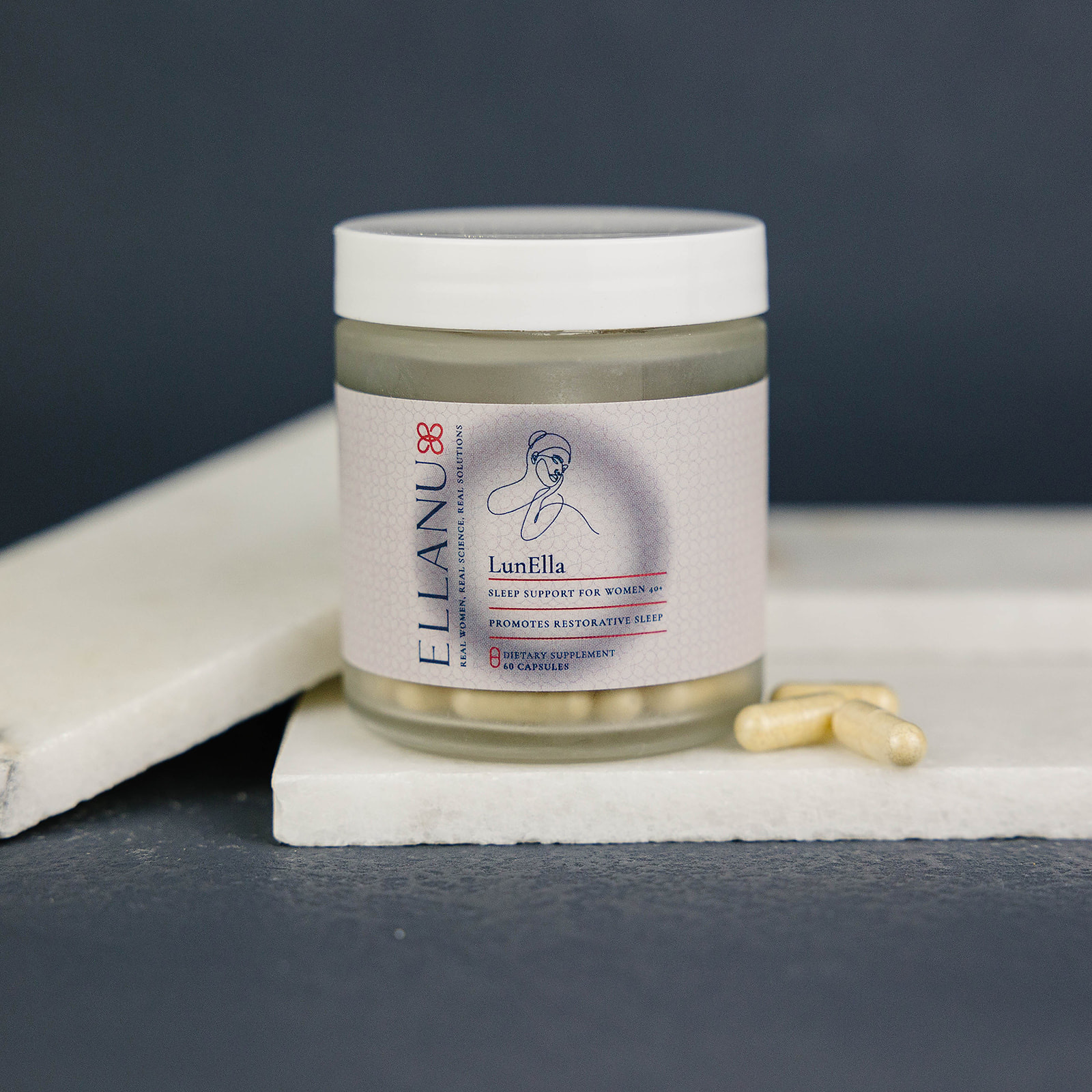 A jar labeled 'LunElla' with capsules on a marble surface.