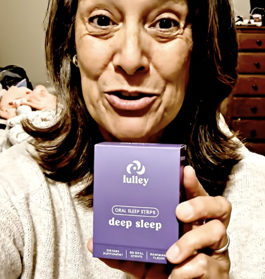 Person holding a box labeled 'lulley deep sleep oral strips.'