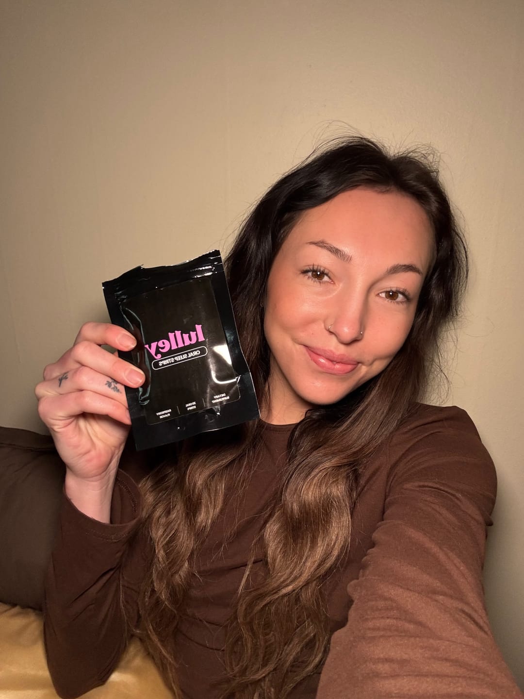 Person holding a packet labeled 'Jullify' and smiling at the camera.